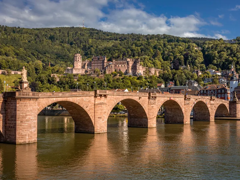 Heidelberg: die Alte Brücke über den Neckar, dahinter das Schloss am Hang